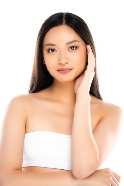 Asyalı kadın kameraya bakıyor ve beyaz tenli yüzlere dokunuyor. 