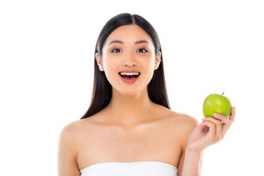 Heyecanlı genç Asyalı kadın kameraya bakıyor ve beyaz üzerinde izole edilmiş elma tutuyor.