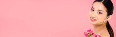 Minik gülleri ve yüzü pembe tomurcuklarla süslenmiş Asyalı bir kadının panoramik fotoğrafı.