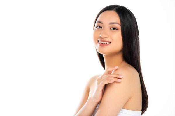 Asian woman touching shoulders and looking at camera isolated on white 