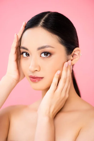 Asiático Mulher Tocando Rosto Enquanto Olhando Para Câmera Isolado Rosa — Fotografia de Stock