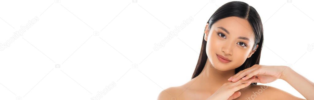 Panoramic shot of young asian woman looking at camera and touching her hands isolated on white