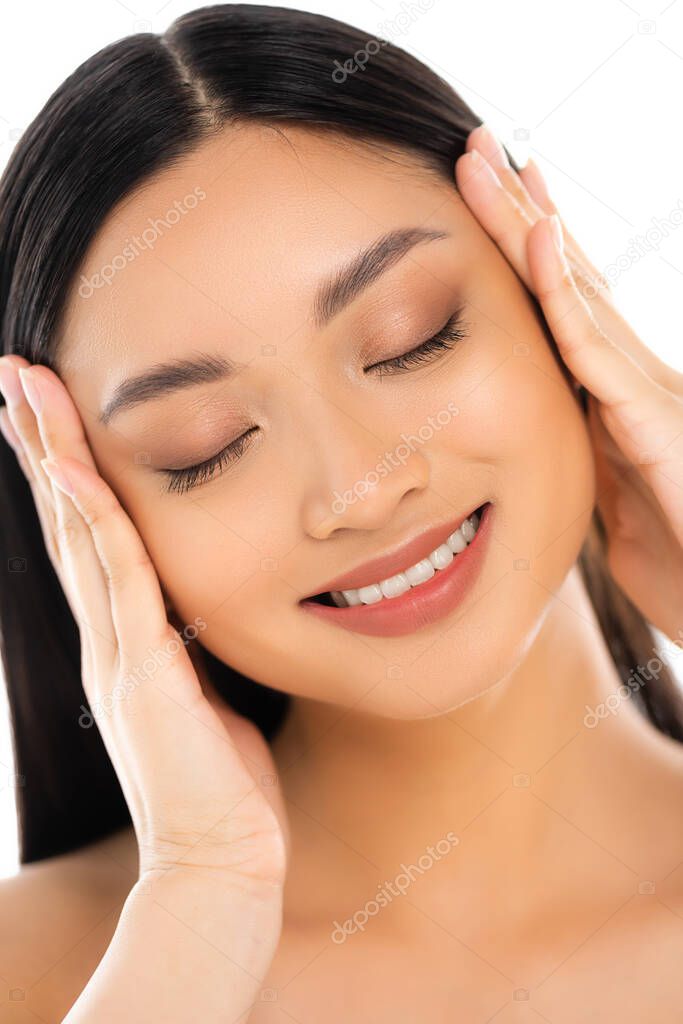 Portrait of young asian woman with closed eyes touching face isolated on white