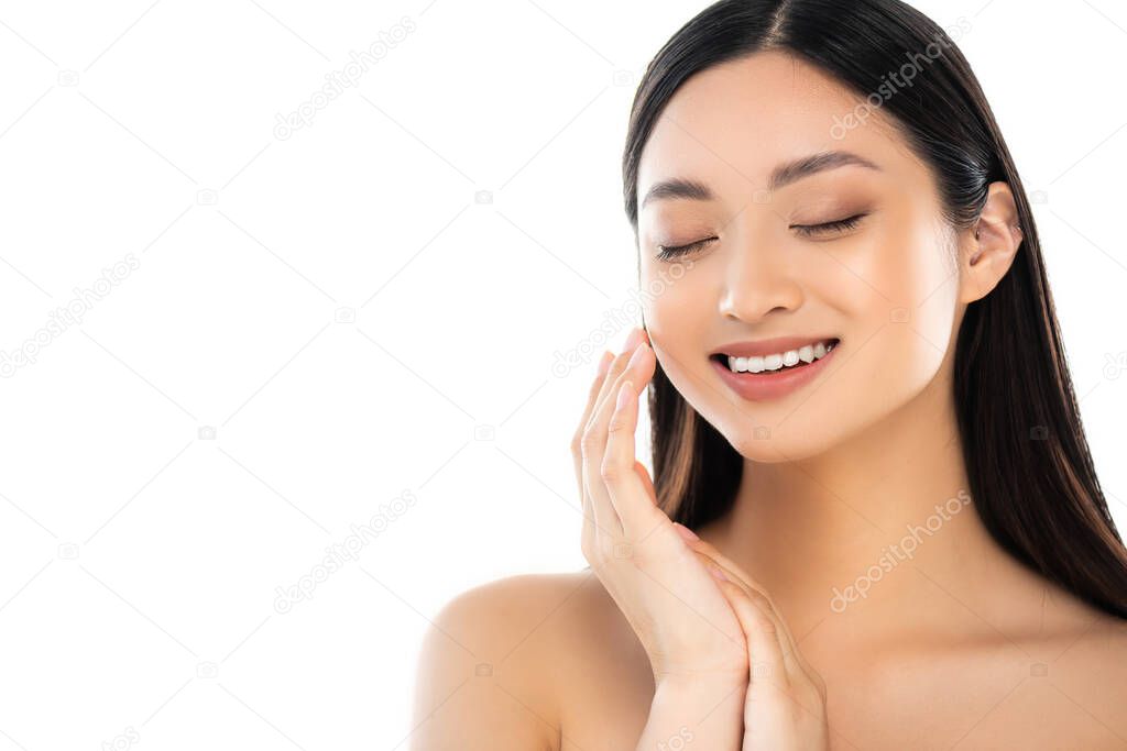 Excited young asian woman with closed eyes touching face isolated on white