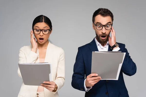 Shocked Interracial Business Partners Eyeglasses Looking Documents Holding Hands Faces — Stock Photo, Image