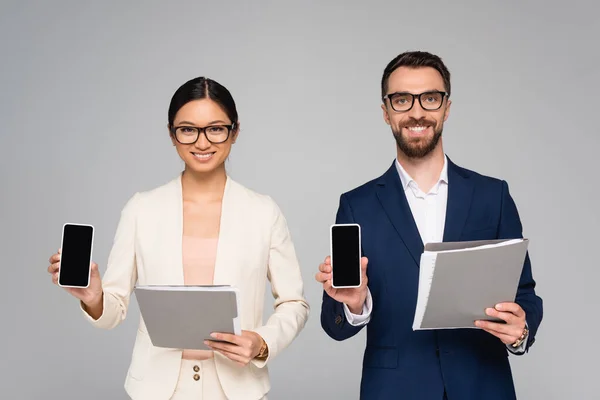 Couple Interracial Business Colleagues Holding Folders Smartphones Blank Screen Isolated — Stock Photo, Image