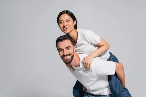 Skäggig Man Vit Shirt Piggybacking Upphetsad Asiatisk Flickvän Isolerad Grå — Stockfoto