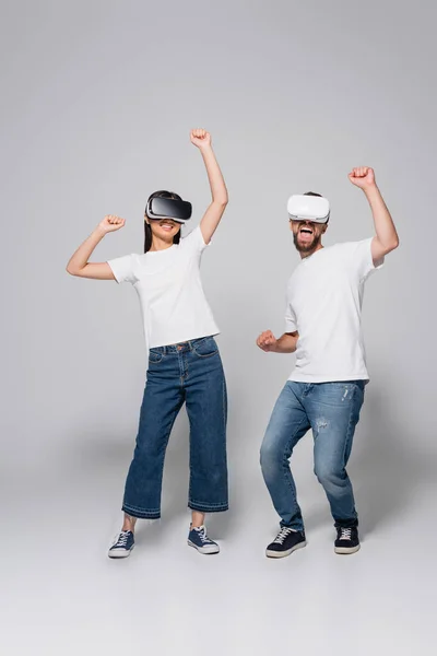 灰色のVrヘッドセットを使用している間にジーンズ ガムシューズ 白いTシャツダンスで興奮したカップル — ストック写真
