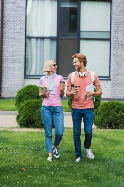 Young Students Holding Paper Cups Books Digital Tablet While Walking — Stock Photo, Image