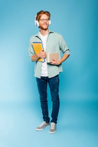 Redhead Bearded Student Glasses Wireless Headphones Holding Books Notepads Blue — Stock Photo, Image