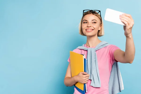 Blonde Student Holding Notebooks Taking Selfie Blue — Stock Photo, Image