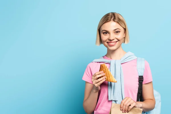 Young Blonde Student Holding Paper Bag Toast Bread Blue — Stock Photo, Image