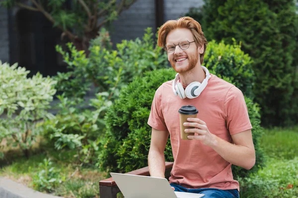 Bebaarde Student Bril Met Papieren Beker Buurt Laptop — Stockfoto