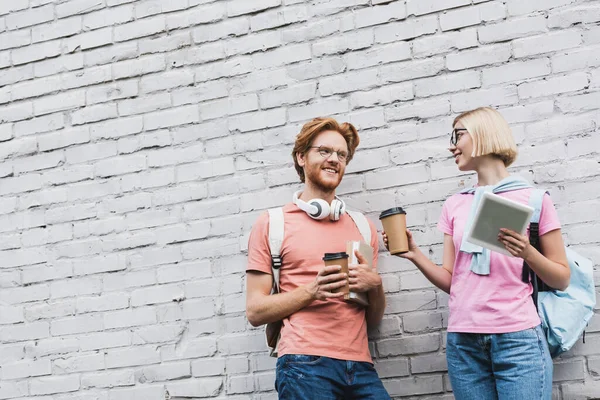 Young Students Holding Coffee Looking Each Other While Standing Brick — Stock Photo, Image