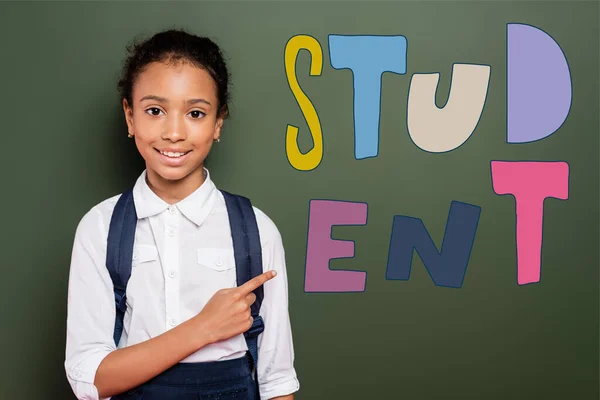 African American Schoolgirl Pointing Finger Green Chalkboard Student Lettering — Stock Photo, Image