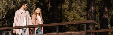 Parkta el ele tutuşan trençkotlu şık çiftin web sitesi başlığı