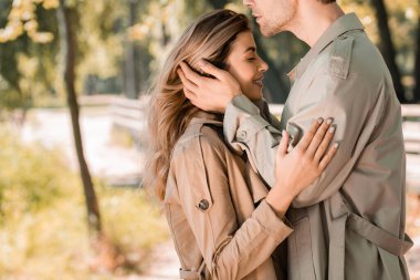 Kadının saçına dokunan adamın yan görüntüsü. Gözleri kapalı.