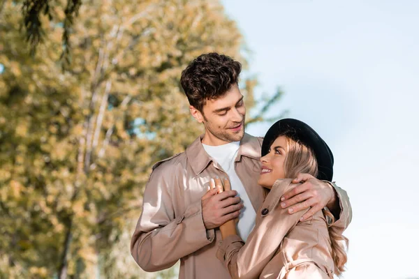 Hombre Gabardina Tocando Mano Mujer Sombrero Exterior —  Fotos de Stock