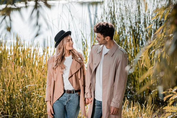 избирательный фокус блондинка в шляпе и мужчина, держащийся за руки снаружи