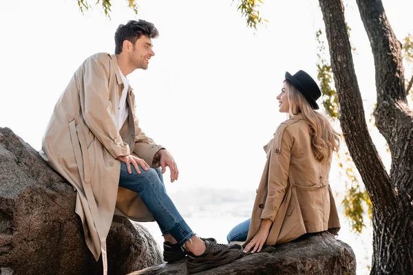 Donna Bionda Cappello Uomo Trench Seduto Pietre Guardarsi Altro — Foto Stock