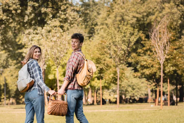 Man Wicker Basket Holding Hands Woman While Standing Park — Stock Photo, Image