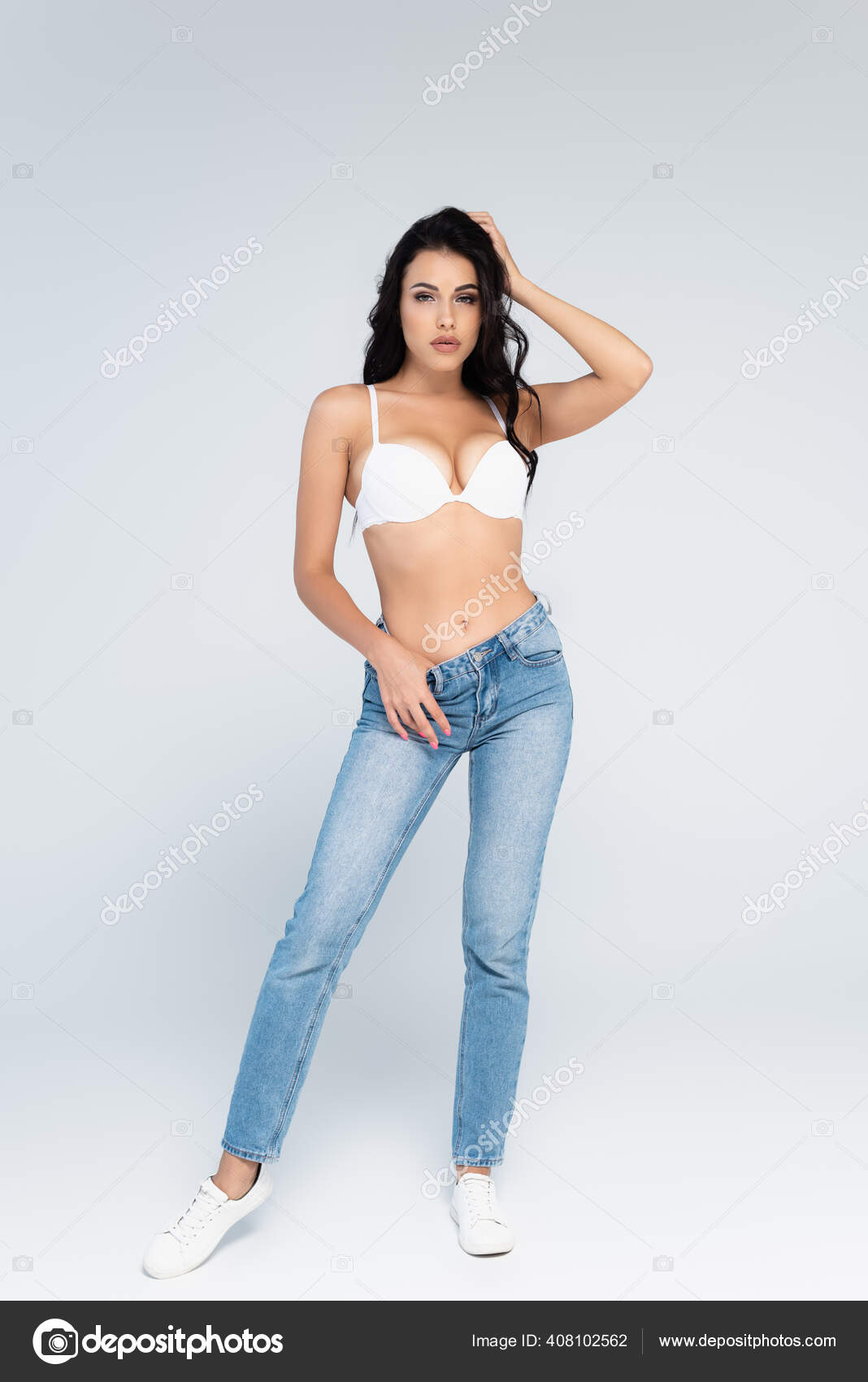 Brunette Woman Bra Jeans Standing Touching Hair Grey Stock Photo by  ©IgorVetushko 408102562