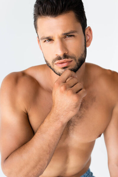 мускулистый и бородатый мужчина касаясь лица, изолированного на белом