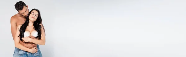 Панорамный Снимок Мускулистого Мужчины Обнимающего Сексуальную Женщину Белом Лифчике Сером — стоковое фото