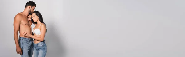 Панорамная Концепция Соблазнительной Женщины Лифчике Касающейся Мускулистого Мужчины Стоящего Сером — стоковое фото