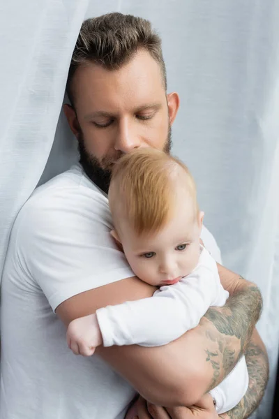 Young Tattooed Man White Shirt Holding Infant Son Hands Closed — Stock Photo, Image