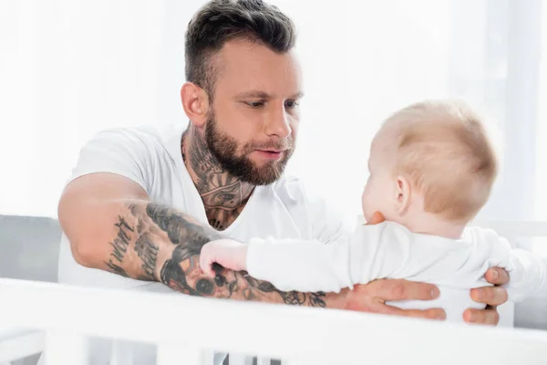 Young Bearded Man Holding Infant Child Crib — Stock Photo, Image