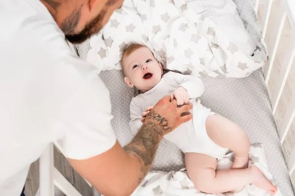 Selective Focus Tattooed Man Touching Infant Kid Lying Crib Open — Stock Photo, Image