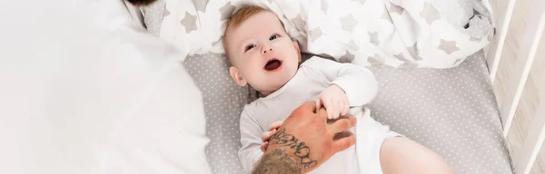 Tattooed Man Touching Infant Child Lying Crib Panoramic Concept — Stock Photo, Image