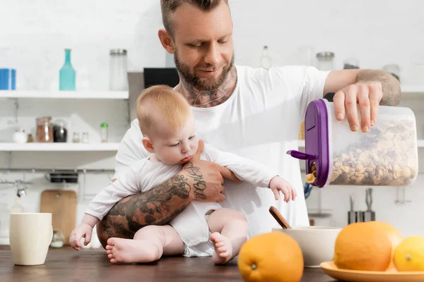 Joven Hombre Tatuado Verter Copos Maíz Tazón Durante Desayuno Con — Foto de Stock