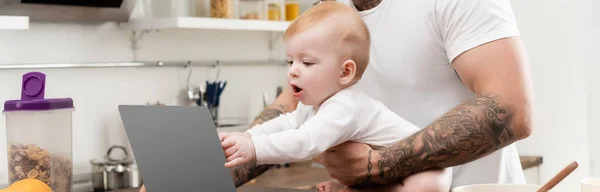Tiro Panorâmico Criança Infantil Tocando Laptop Perto Pai Tatuado Cozinha — Fotografia de Stock