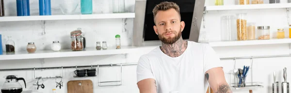 Panoramic Crop Young Tattooed Man Looking Camera While Standing Kitchen — Stock Photo, Image