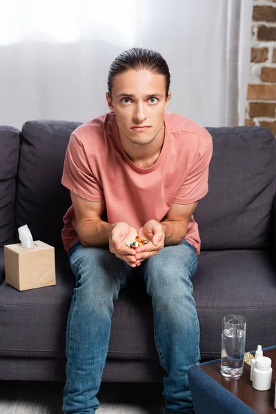 Diseased Young Man Holding Handful Pills While Sitting Sofa Medicines — Stock Photo, Image
