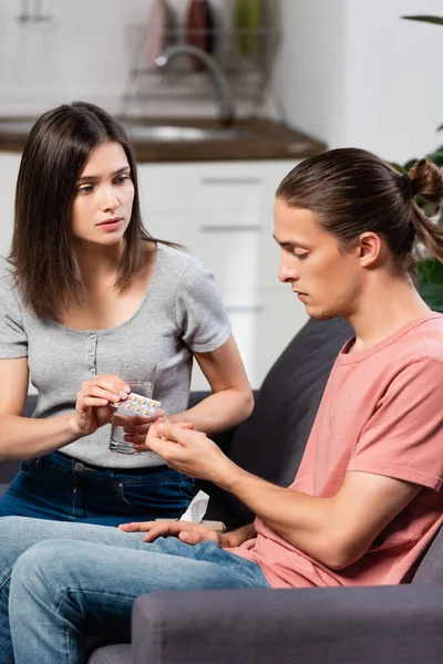 Ung Kvinna Hålla Glas Vatten Och Piller Till Sjuka Man — Stockfoto