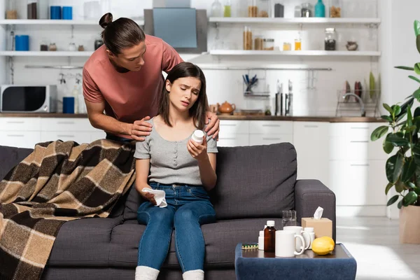 Man Touching Diseased Woman Sitting Sofa Kitchen Holding Bottle Pills — Stock Photo, Image