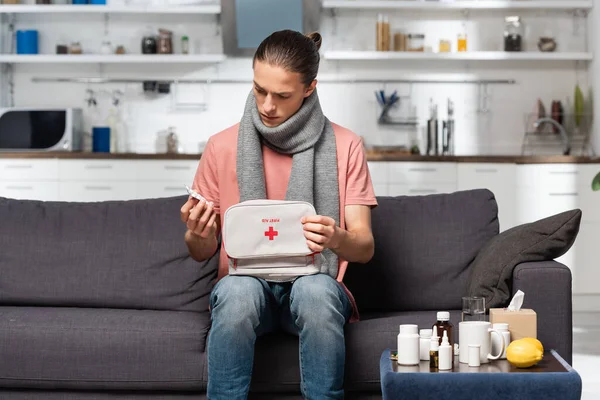 Malato Giovane Uomo Con Kit Pronto Soccorso Tenendo Spray Gola — Foto Stock