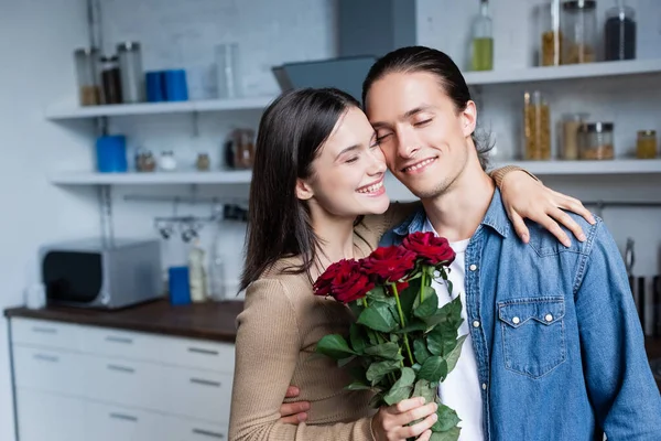 Woman Holding Bouquet Roses Embracing Man Closed Eyes While Standing — Stock Photo, Image