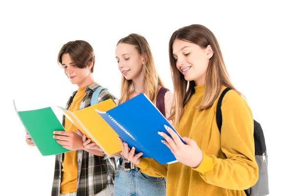 Sonriente Adolescente Mirando Cuaderno Cerca Amigos Aislados Blanco — Foto de Stock