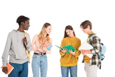 Kitapları, dizüstü bilgisayarı ve dizüstü bilgisayarı olan pozitif çok kültürlü gençler beyaza izole edilmiş.