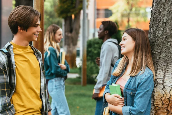 Accentul Selectiv Adolescentului Zâmbitor Carte Vorbind Prieten Lângă Copac Aer — Fotografie, imagine de stoc