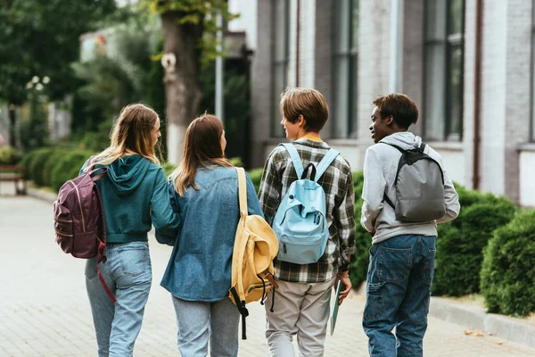 Vista Trasera Adolescentes Multiétnicos Con Mochilas Caminando Juntos Calle — Foto de Stock