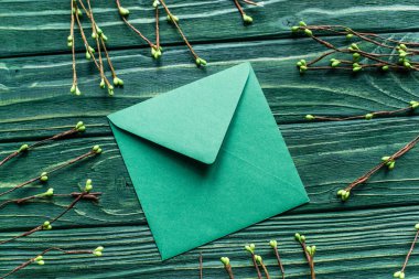 top view of wooden green background with blossoming branches and envelope clipart