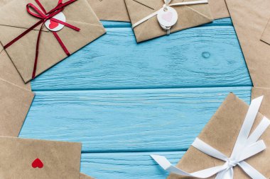 top view of wooden blue background with envelopes and hearts clipart