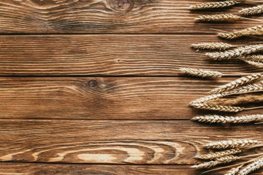 top view of wheat ears border on wooden background clipart