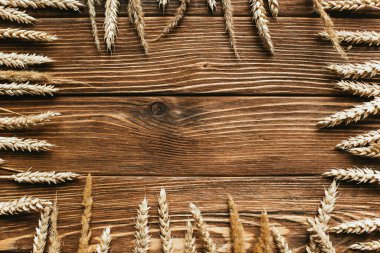 top view of wheat ears frame on wooden background clipart