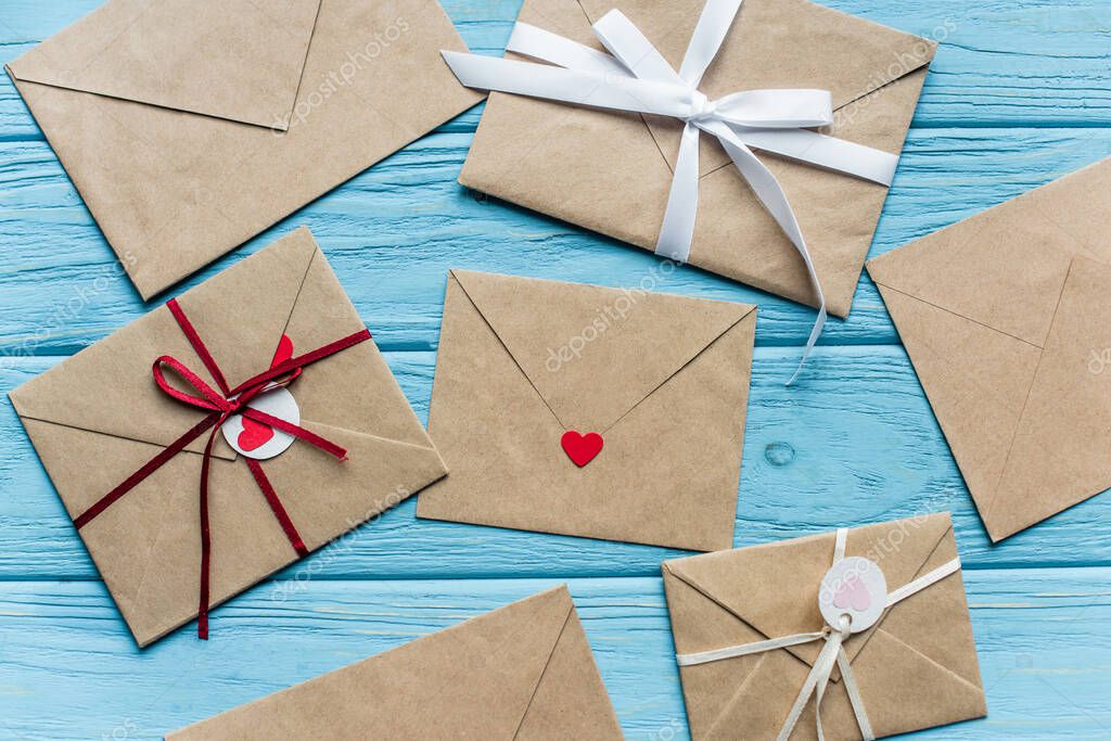 Top view of wooden blue background with envelopes and hearts